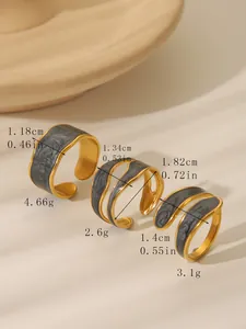 Detail of three vintage gold open rings with marble enamel in varied geometric designs