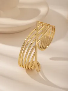 Dettaglio macro del bracciale rigido multistrato placcato oro con accenti floreali