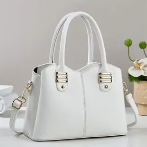 Close-up of white lychee textured leather handbag with elegant gold metal buckles