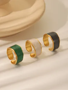Three enamel rings in green, white, and grey with gold wavy irregular edges