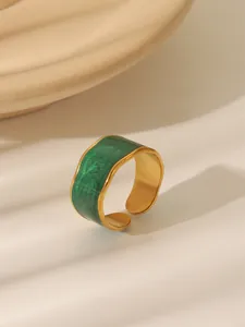 Detail of vintage gold ring with green enamel inlay and irregular wavy edges