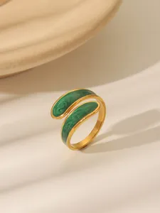 Detailed macro of vintage gold ring with green marble enamel and fluid wrap design