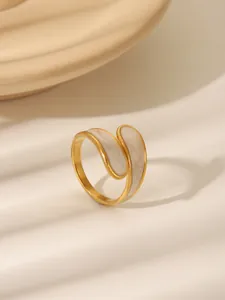 Detailed macro view of gold plated ring with marble enamel inlay and streamline design