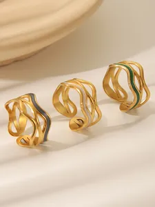 Detailed view of three gold wave rings featuring black white and green enamel drips