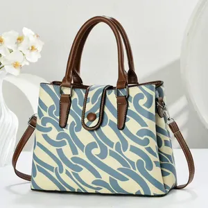 Chic blue and white patterned canvas tote bag with brown leather handles and strap