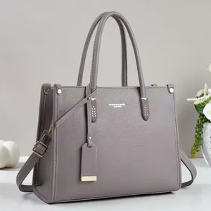 Grey pebbled leather tote bag with dual handles and adjustable strap for daily use