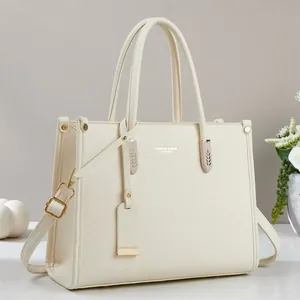 Elegant white tote bag in textured leather with gold hardware and dual handles
