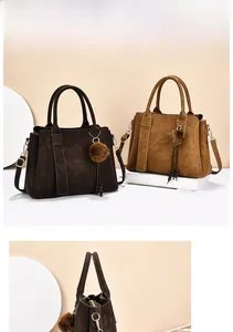 Vue détaillée du grand sac cabas avec profil latéral, pompon en peluche et pendentif