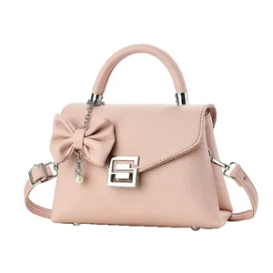 Elegant light pink lychee pattern handbag with bow decoration and pearl pendant accessory