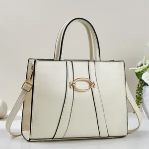 Close-up of cream white handbag featuring a gold oval clasp and premium texture