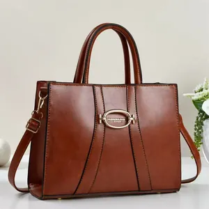 Close-up of brown vintage handbag with gold oval hardware and detailed leather texture