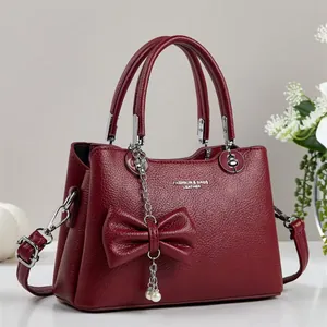 Sac à main chic bordeaux en cuir litchi avec nœud perlé et bandoulière réglable