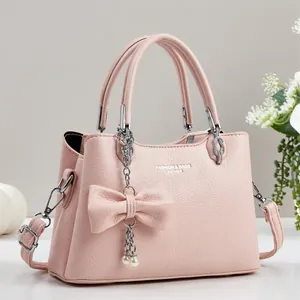 Pink lychee texture handbag with elegant pearl bow and adjustable shoulder strap