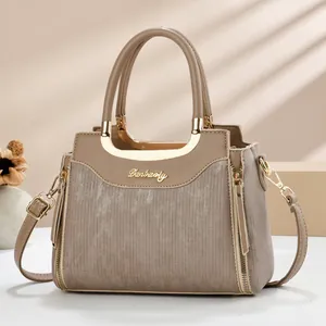 Détails d'un sac à main beige avec ferrures dorées et texture de cuir à lignes verticales