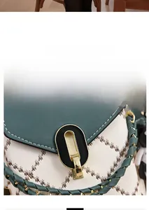 Détail du fermoir en métal sur un sac à bandoulière en cuir blanc et vert forêt