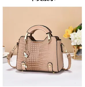 Detail of crocodile embossed faux leather bag with glossy finish and pearl rabbit charm