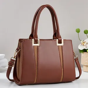Detailansicht der braunen Ledertasche mit feinen Texturen und goldenen Metallelementen