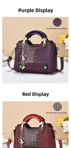 Detail of crocodile pattern leather bag featuring a cute rabbit charm and metal handle