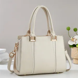 Detail der cremeweißen Handtasche mit geflochtener Struktur und goldener Hardware