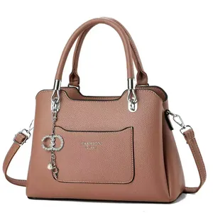 Detail of dusty pink pebbled leather handbag with silver hardware and fashion queen text
