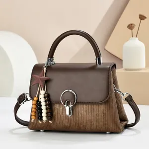 Classic brown paneled crossbody bag with silver round lock and star beaded pendant charm
