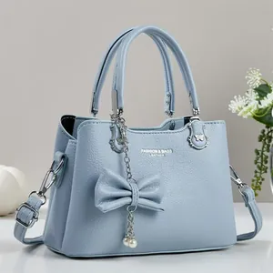 Detailansicht hellblaue Lederhandtasche mit großer Schleife und Perlen Metallkette