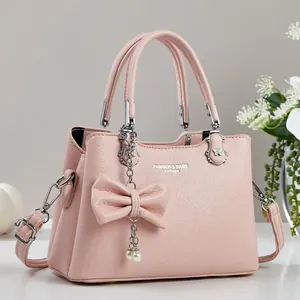 Rosa Damen Handtasche aus Leder mit Schleife und Perlenanhänger Design