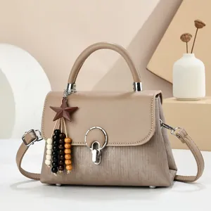 Elegant apricot flap handbag with wooden star charm and silver lock in minimalist setting