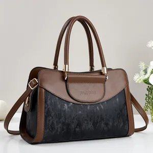 Elegant two-tone leather handbag with brown and black panels and golden metal hardware