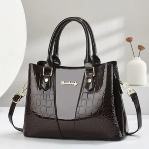 Elegant deep brown crocodile textured leather handbag with gold accents and shoulder strap