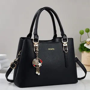 Sac bandoulière chic en cuir noir grainé avec détails dorés et pendentif étoile