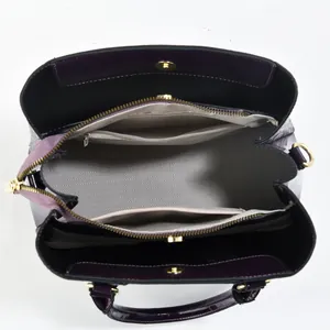 Top view of deep purple patent leather bag showing interior compartments and herringbone lining