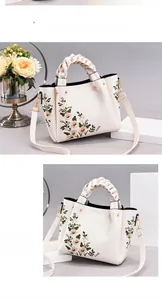 Detail view of white leather bag featuring green floral embroidery and braided handle