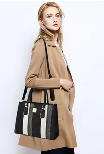 Detail view of striped tote bag with adjustable leather strap and golden logo