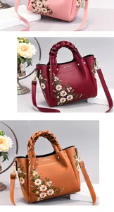 Detail of delicate daisy embroidery and woven leather handle on stylish women handbag