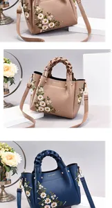 Detailed view of floral embroidery and woven handle on elegant shoulder bag for women