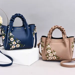 Chic embroidered tote bag with woven handles in navy blue and beige faux leather