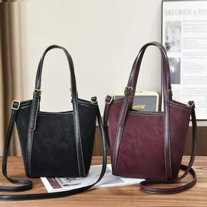 Dettagli di borse tote in pelle scamosciata opaca e liscia in nero e bordeaux scuro