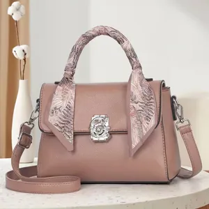 Close-up of pebble leather handbag with floral scarf handle and vintage silver clasp