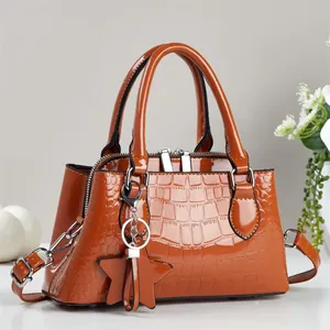 Detail of caramel brown crocodile embossed patent leather handbag with star charm