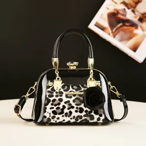 Chic black patent leather shell bag with leopard print, gold hardware and rose charm