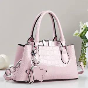 Pink patent leather crossbody bag with stone texture, star pendant and top handles