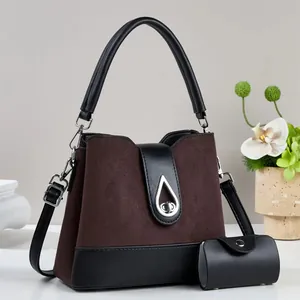Close-up of the elegant brown suede patchwork handbag with a silver teardrop twist lock
