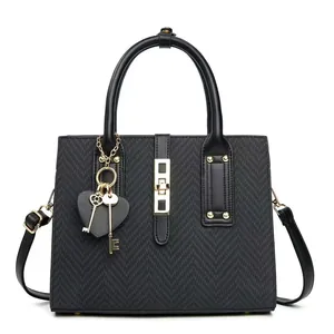 Women's black herringbone top handle bag with gold lock and decorative charms