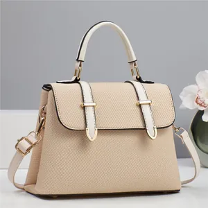 Detailed shot of beige woven fabric bag with cream leather trim and gold metal hardware