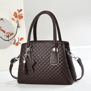 Dark brown quilted leather tote bag with silver hardware and a star pendant accessory