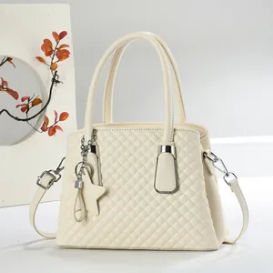Ivory quilted leather handbag with star pendant, double handles, and crossbody strap
