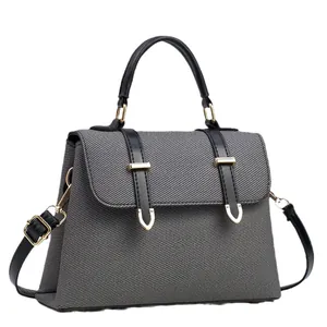 Gray textured canvas tote bag with black leather straps and gold metal U-shaped buckles