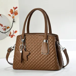 Detail of a brown quilted handbag with star pendant and textured leather stitching