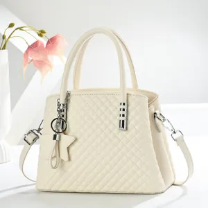 Detail der cremefarbenen Stepptasche mit Sternanhänger und Schultergurt